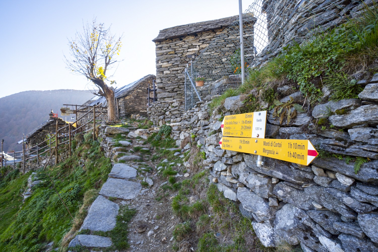 Près du hameau de Faedo ; des maisons rustiques en pierre et des murs en pierre sèche bordent le chemin. Photo: Wanderblondies